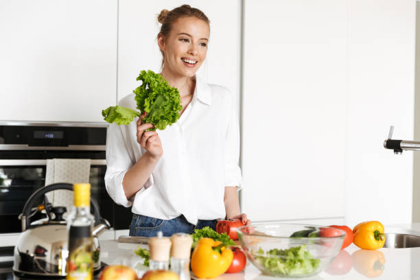 istock Beautiful woman standing in kitchen cooking 1325228416