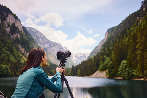 Young camper woman photographing landscape with camera