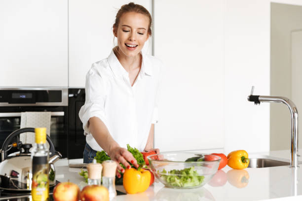 istock Beautiful woman standing in kitchen cooking 1325229996
