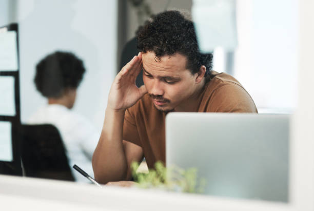 istock Shot of a handsome young businessman sitting in the office and feeling stressed while using his cellphone 1325230179