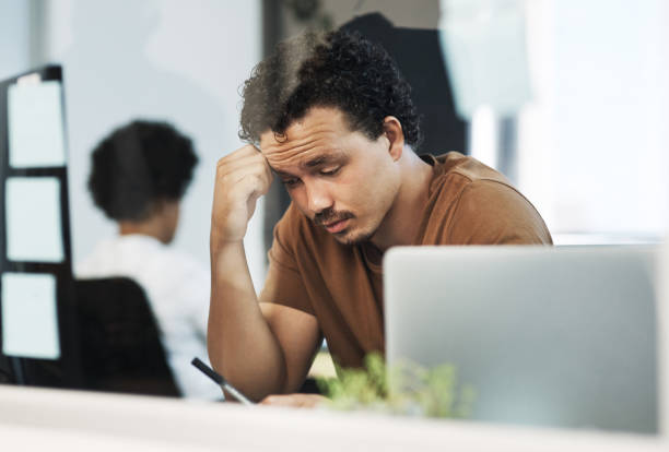 istock Shot of a handsome young businessman sitting in the office and feeling stressed while using his cellphone 1325230195