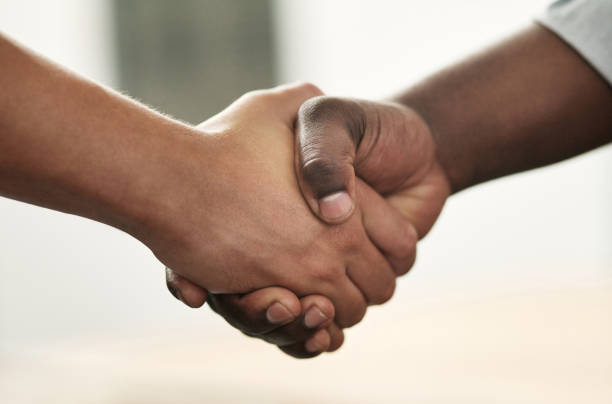 cropped shot of a two unrecognizable businessmen standing in the office together and shaking hands - apertar a mão imagens e fotografias de stock