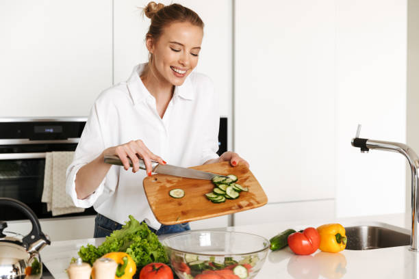 istock Beautiful woman standing in kitchen cooking. 1325231387