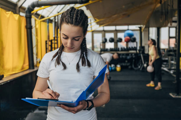 istock Female fitness trainer writing schedule 1325234224