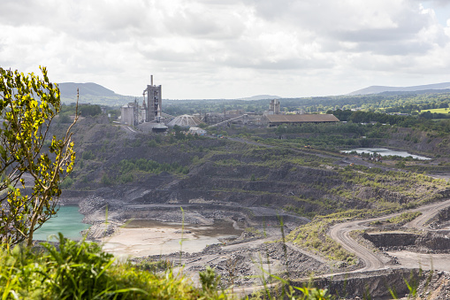 Cement production factory next to a deep limestone quarry