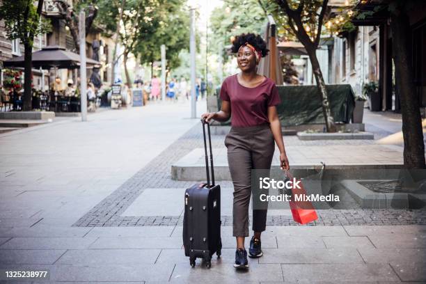 Young Afro Woman Arriving To The City And Walking With Her Suitcase Stock Photo - Download Image Now