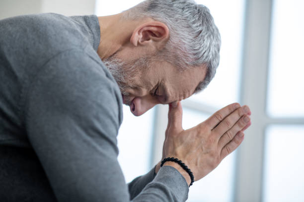 istock A gray-haired man sitting with eyes closed and saying the payers 1325239836