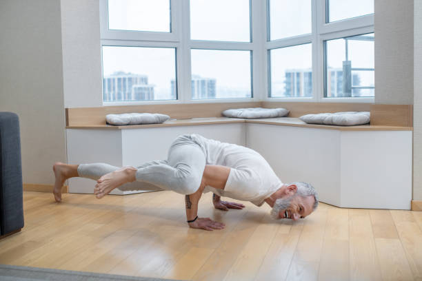 istock A mature yogi exercising at home and looking involved 1325239947