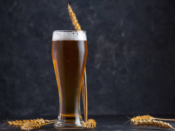 istock Tall glass of light or wheat beer on a black background 1325241955