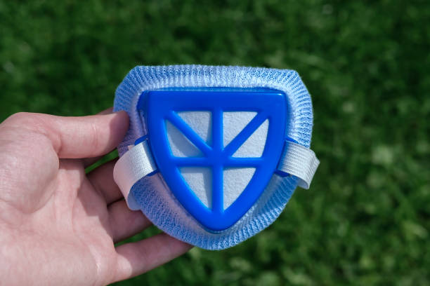 istock Blue respirator with an elastic band in his hand on a background of grass. 1325242553