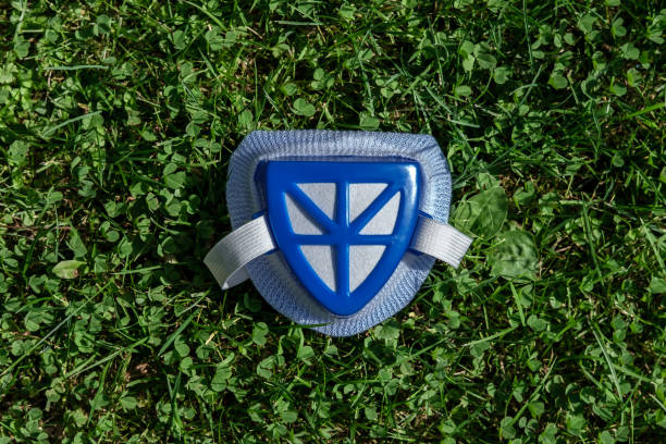 A blue respirator with an elastic band lies on the grass.