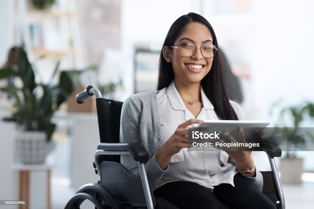 Cropped portrait of an attractive young businesswoman in a wheelchair using her tablet in the office - Royalty-free Engelli Kişiler Stok görsel Cropped portrait of an attractive young businesswoman in a wheelchair using her tablet in the office - Royalty-free Engelli Kişiler Stok görsel