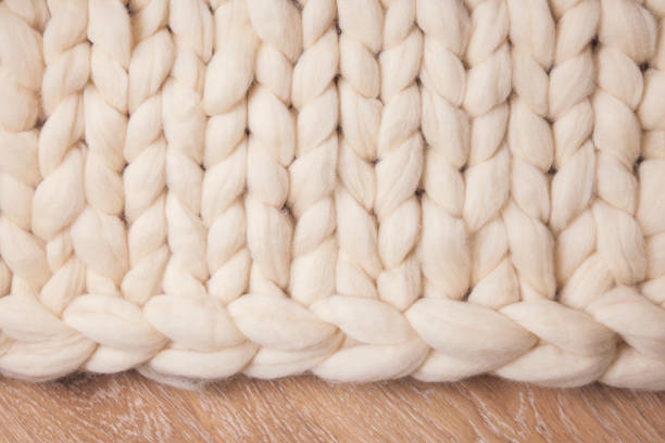 istock Blanket of thick yarn or merino wool plaid on floor. Background flat lay with copyspace 1325244479