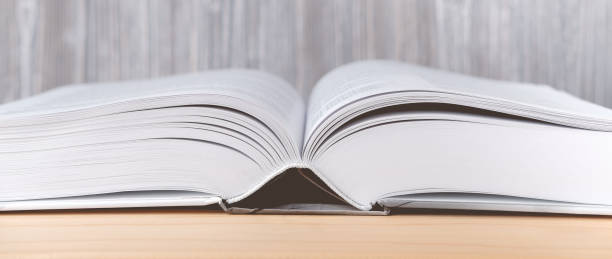istock The open book lies on a wooden table. 1325246403