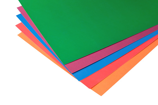 Sheets of colored paper isolated on a white background. Multi-colored thin cardboard lay on top of each other. Hobby and DIY items.