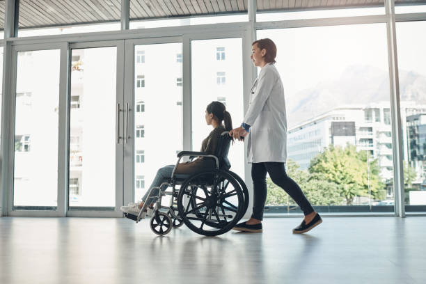 Shot of a young female doctor pushing a patient in a wheelchair in a hospital Another patient treated successfully demobilization photos stock pictures, royalty-free photos & images