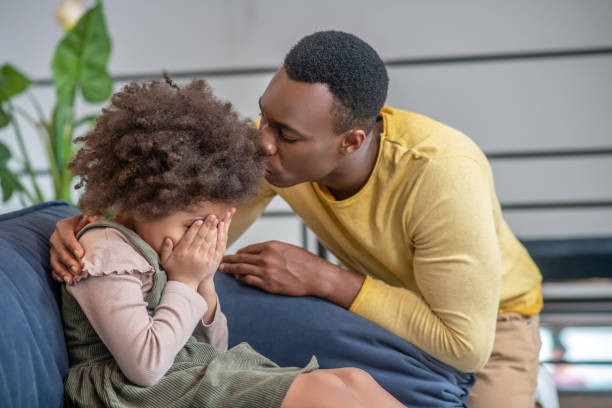 istock Dad soothes sad daughter covering her face 1325250198