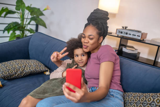 istock Cheerful mom with daughter taking selfie on smartphone 1325250466