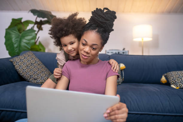 istock Smiling mom with daughter looking at laptop screen 1325250589