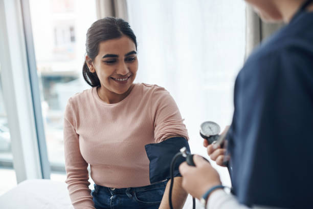 colpo di un medico irriconoscibile che controlla la pressione sanguigna di un paziente in un ufficio - visita foto e immagini stock