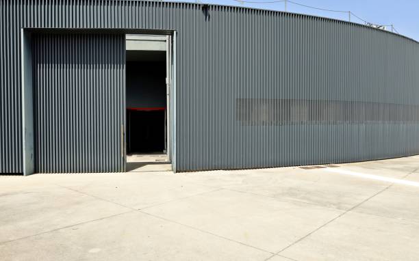 istock Black circular wall made of aluminium cladding with a large concrete pavement in front. 1325251667