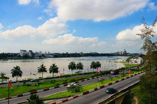 Abidjan, Ivory Coast / Côte d'Ivoire: traffic on Boulevard Charles de Gaulle, the Plateau's waterfront avenue with the Aqualines Plateau boat station - Treichville, Petit Bassam island, in the background - Palace of Culture and Félix Houphouët-Boigny Bridge.