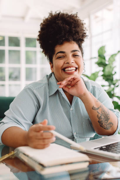 istock Woman smiling while sitting at desk 1325256755