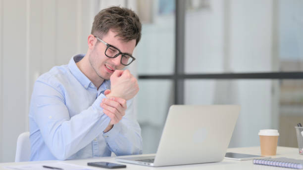 istock Young Man with Laptop having Wrist Pain 1325257717