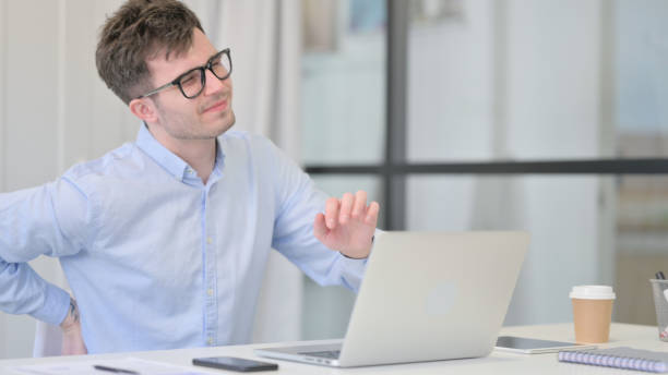 istock Young Man with Laptop having Back Pain 1325257732