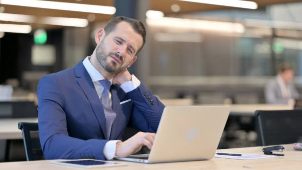 istock Middle Aged Businessman having Neck Pain At Work 1325258370