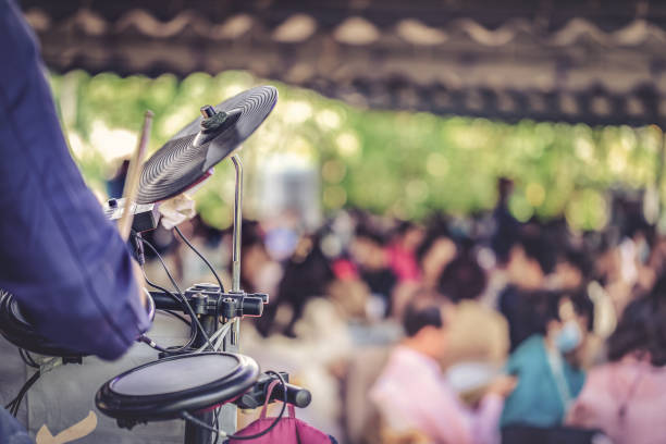 um músico toca bateria em um show no meio de um parque público. - popular culture - fotografias e filmes do acervo