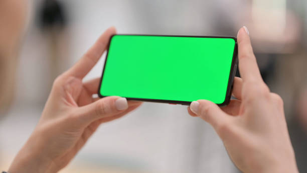 istock Female Watching Smartphone with Green Chroma Key Screen 1325263187