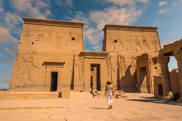A young tourist visiting the Temple of Philae, a Greco-Roman construction seen from the Nile River, a temple dedicated to Isis, goddess of love. Aswan. Egyptian