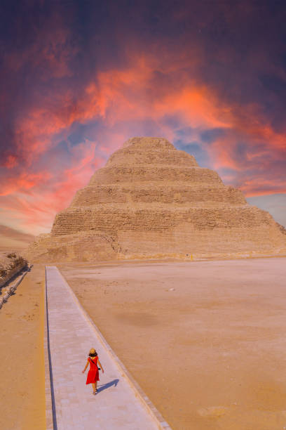 una giovane donna in visita alla piramide a gradoni di djoser, saqqara. egitto. la necropoli più importante di memphis. la prima piramide al mondo - saqqara foto e immagini stock
