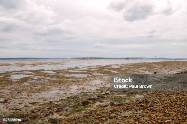 Calshot Beach Hampshire At Low Tide Stock Photo - Download Image Now - Atmosphere, Beach, Cloud - Sky