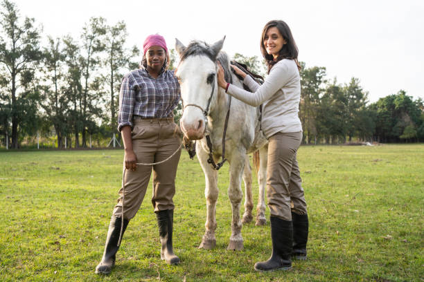 ritratto di due donne con un cavallo in scuderia - training african descent business multi ethnic group foto e immagini stock