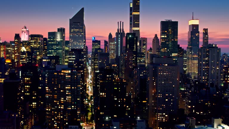 Aerial establishing shot of New York City on a summer evening, taken from over the East River and looking towards Midtown Manhattan.