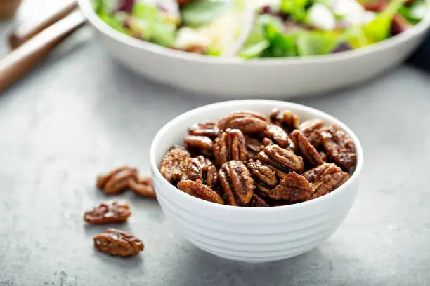 Caramelized or candied pecans for appetizer or salad in white bowl