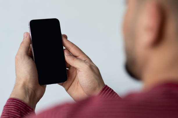 Unrecognizable guy using smartphone with blank screen