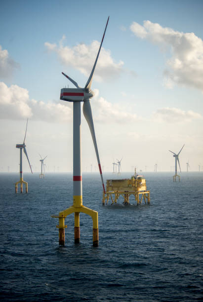 turbinas de parques eólicos marinos al anochecer en medio del mar - plataforma petrolera fotografías e imágenes de stock
