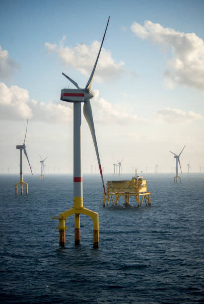 turbine eoliche offshore al crepuscolo in mezzo al mare - sea wind turbine turbine wind foto e immagini stock