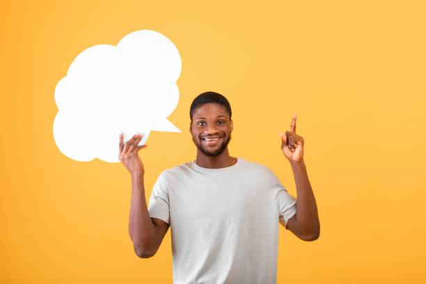 istock I have creative idea. Inspired african american guy holding an empty speech bubble above his head over yellow background 1325275086