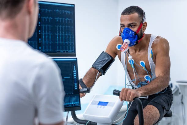 atleta montando una bicicleta estática en un laboratorio durante las pruebas biométricas - deporte y salud fotografías e imágenes de stock