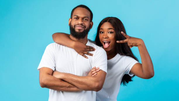 istock Black couple posing showing victory sign or peace gesture 1325276332