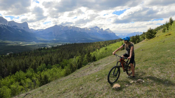 istock Female mountain biker relaxes on grassy mountain ridge 1325277194