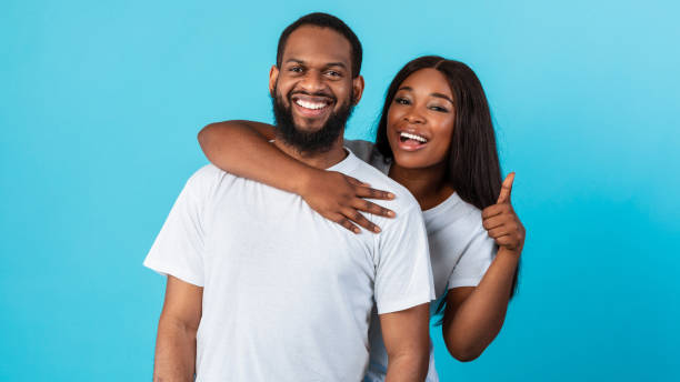 istock Happy afro couple gesturing thumbs up and smiling 1325277894