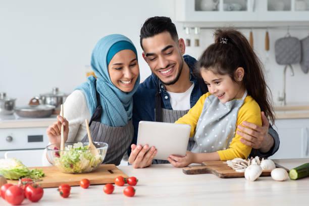 istock Happy Muslim Family Using Digital Tablet While Cooking In Kitchen Together 1325278755