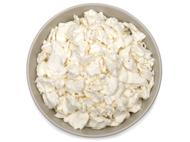 istock Cottage cheese in a plate. Fresh cottage cheese on a white background. Homemade curd in minimalism style. Top view. 1325279708