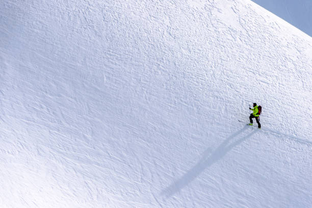 vista aerea dello sciatore di backcountry che scala le montagne rocciose canadesi - skiing snow mountain canada foto e immagini stock