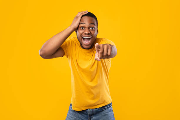 istock Excited African Guy Pointing Finger At Camera Laughing, Yellow Background 1325281892